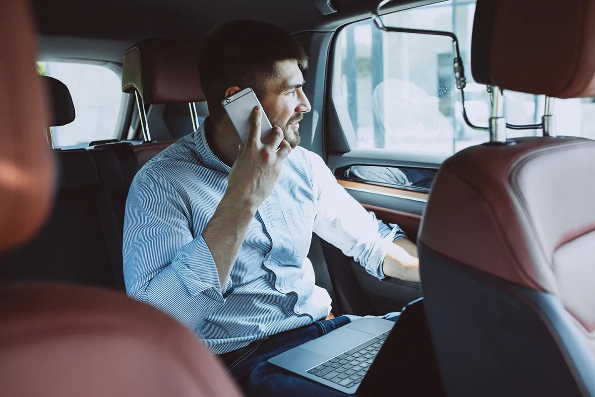 beau-homme-d-affaires-travaillant-sur-un-ordinateur-en-voiture